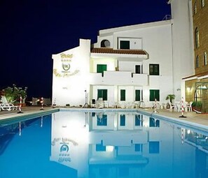 Una piscina al aire libre de temporada, sombrillas