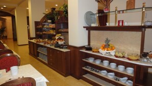 Disposição de buffet com diversos alimentos e pratos.
