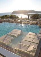 Una piscina al aire libre de temporada, sombrillas