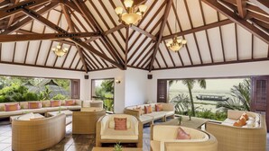 A spacious indoor area with wicker furniture, a high ceiling with wooden beams, and a view of the sea. - The Zuri Kumarakom Kerala Resort & Spa (Kottayam)