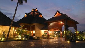 A resort with multiple buildings, a covered walkway, and palm trees. - The Zuri Kumarakom Kerala Resort & Spa (Kottayam)