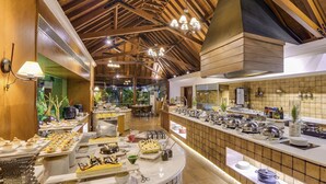A buffet area with various food items and a counter with dishes and utensils. - The Zuri Kumarakom Kerala Resort & Spa (Kottayam)