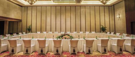 A conference room with a long table, chairs, and a floral centerpiece.