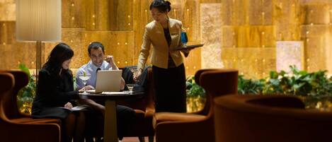 A hotel lobby with a large, ornate wall and a reception desk.
