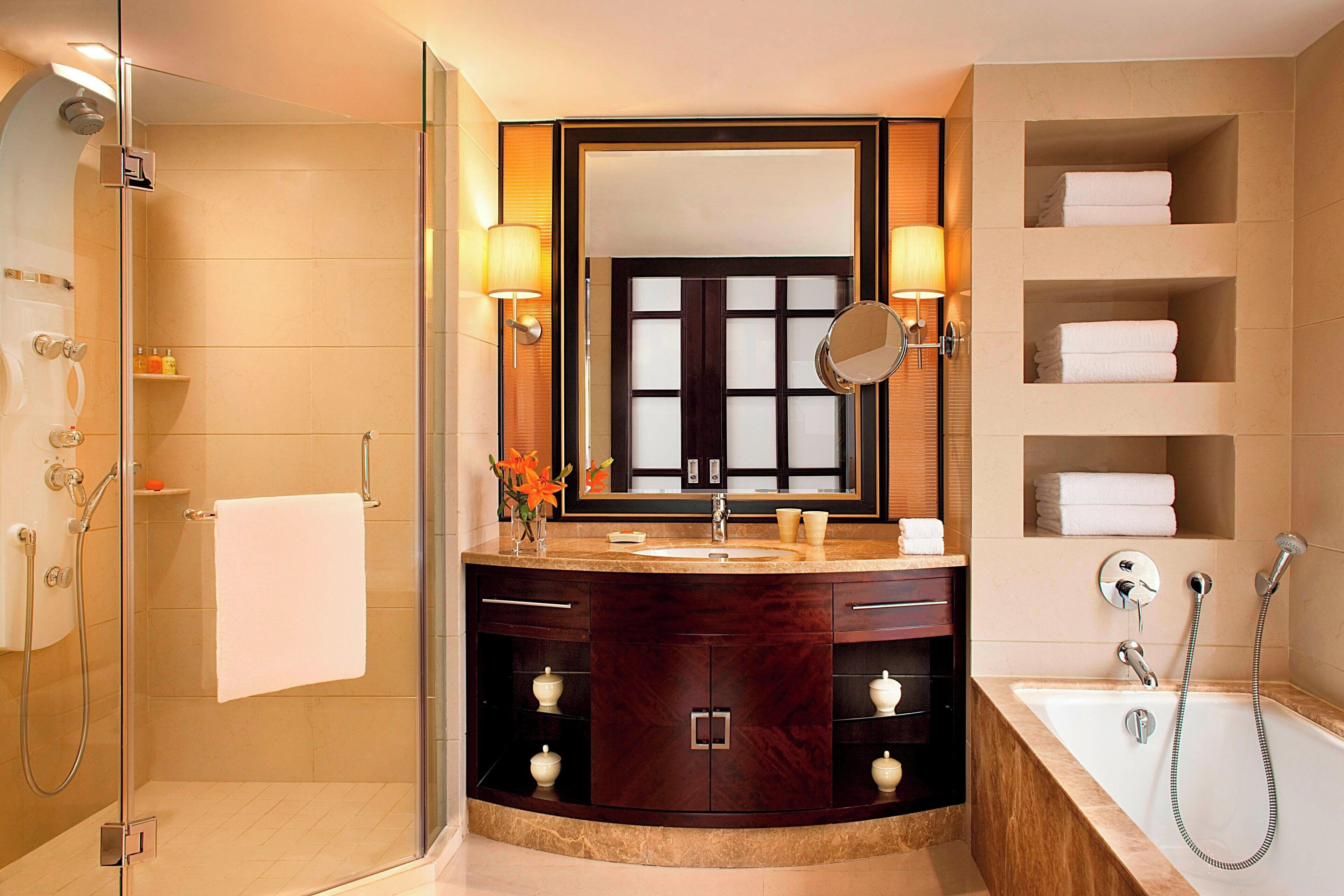 A modern bathroom with a glass-enclosed shower, a vanity with a mirror, and a bathtub.