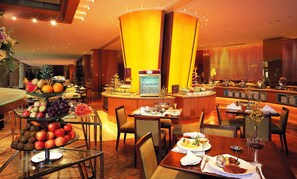 A hotel dining area with multiple tables, a buffet with various food items, and a coffee machine. - Sheraton Ningbo Hotel (Ningbo)