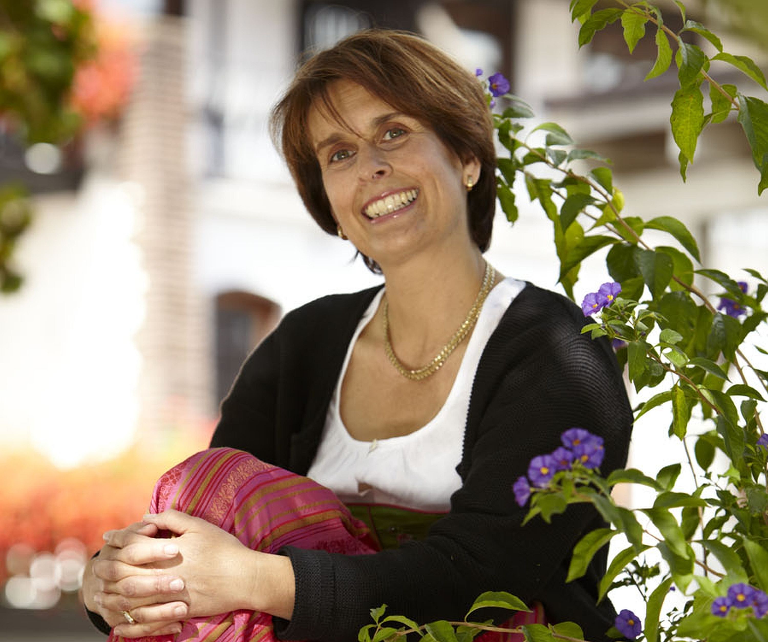 A person sitting outdoors with a building in the background.