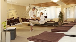 A spa room with hanging chairs, a massage table, and a potted plant. - Landgasthof Hotel Hirsch (Lossburg)