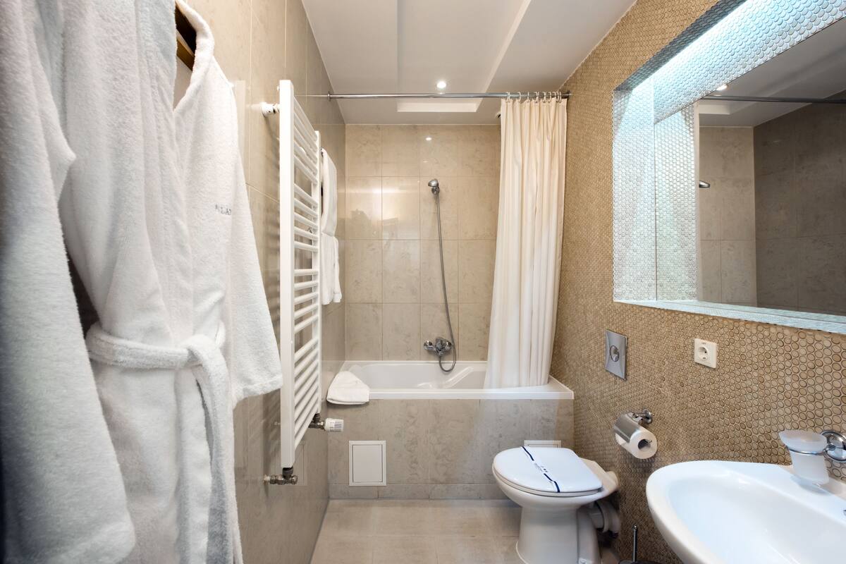 A modern bathroom with a bathtub, toilet, and sink.