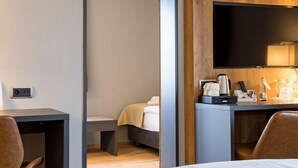 Une chambre d’hôtel moderne équipée d’un lit, d’un bureau et d’une télévision.