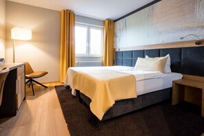 Une chambre d’h ôtel moderne, dotée d’un grand lit, d’un bureau et d’une chaise.