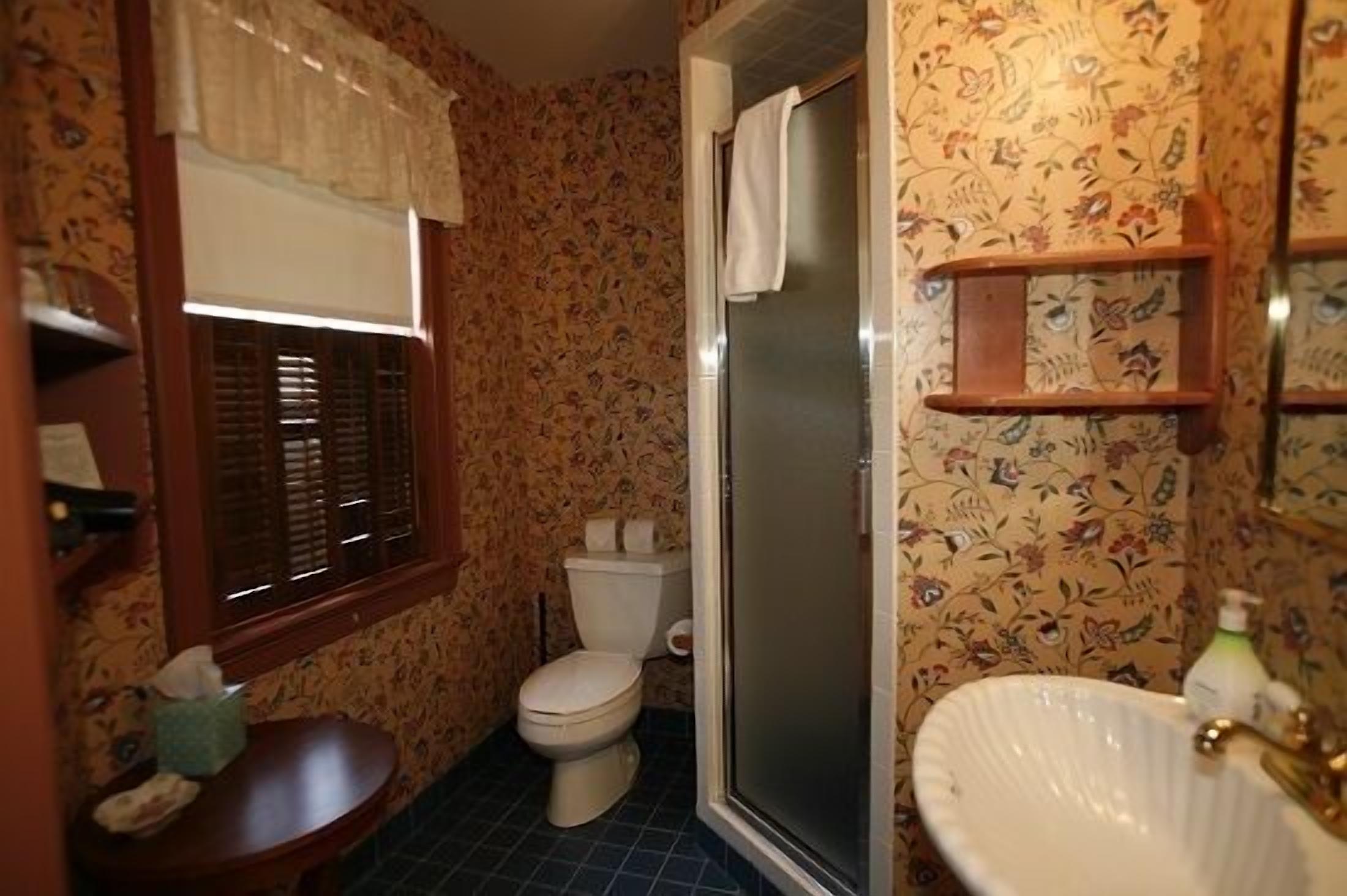 A bathroom with a toilet, sink, and shower.
