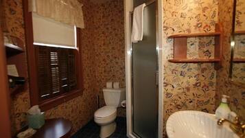 A bathroom with a toilet, sink, and shower.