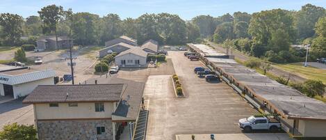 A parking lot with several buildings, including a house with a stone facade and a sign that reads "HOMES".