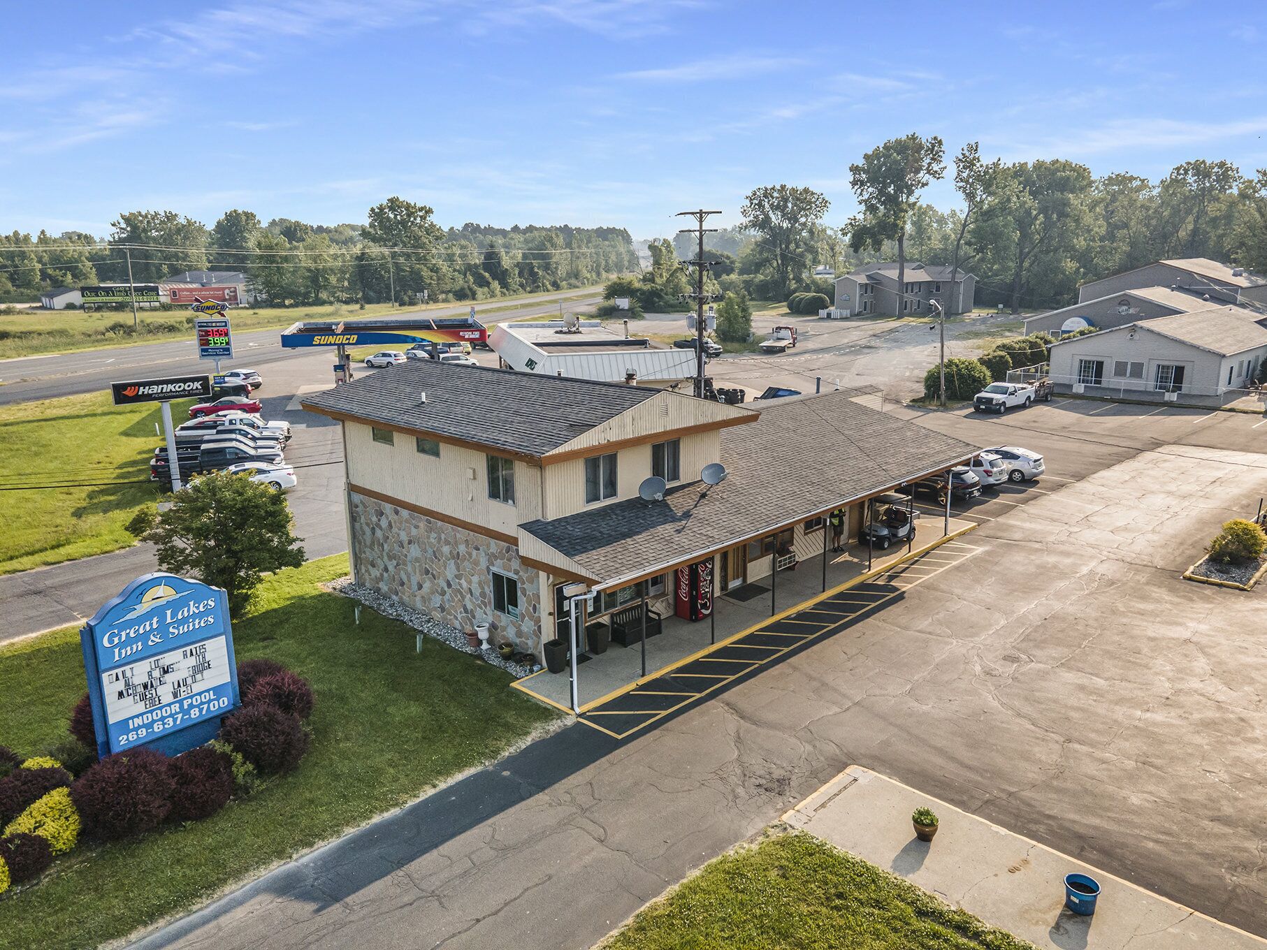 Un motel con fachada de piedra, un estacionamiento y un letrero que dice Great Lakes Suites.