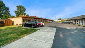 Fileira de edifícios de motel com estacionamento na frente.