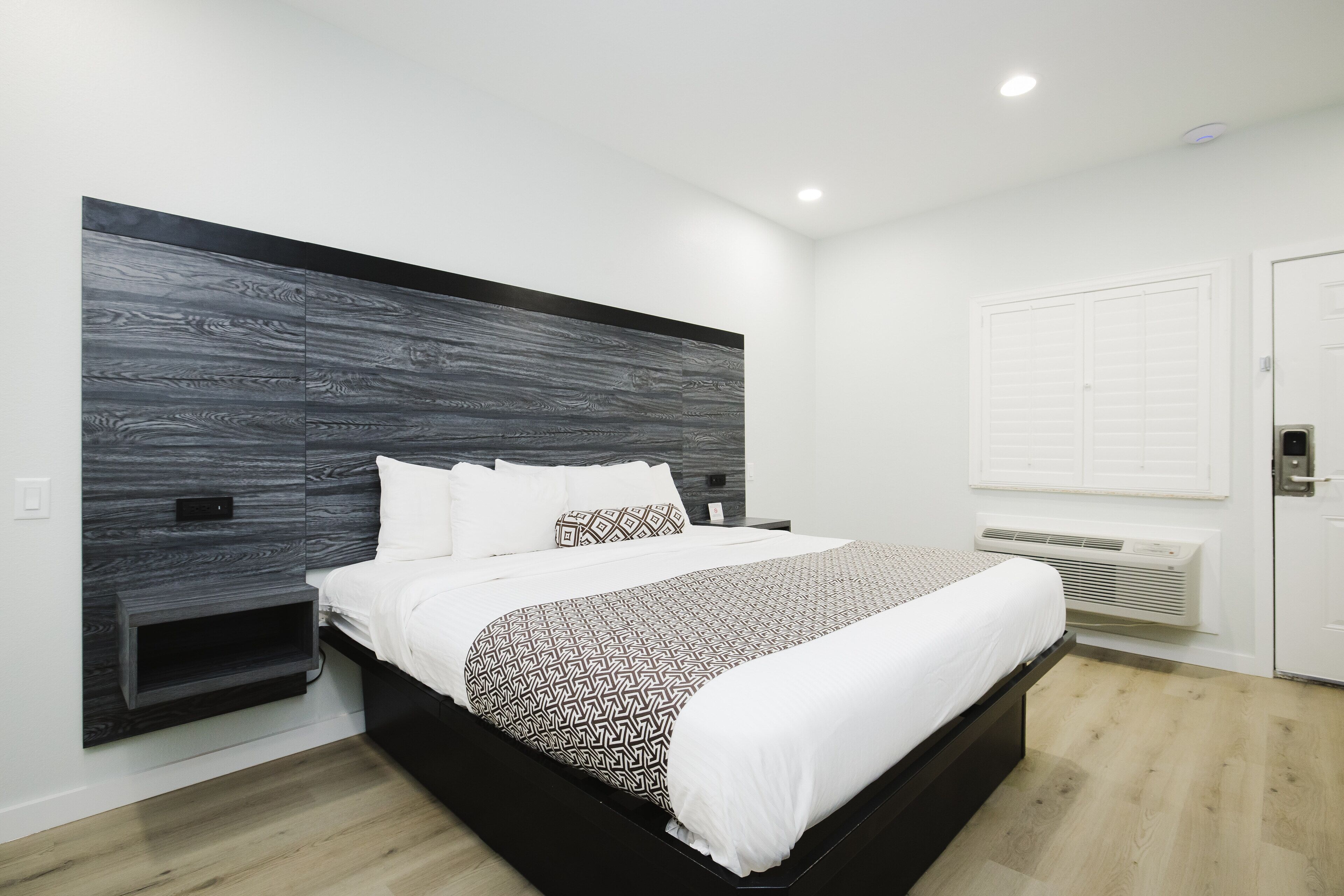 Een moderne hotelkamer met een groot bed, een inbouwkast en een witte garderobe.