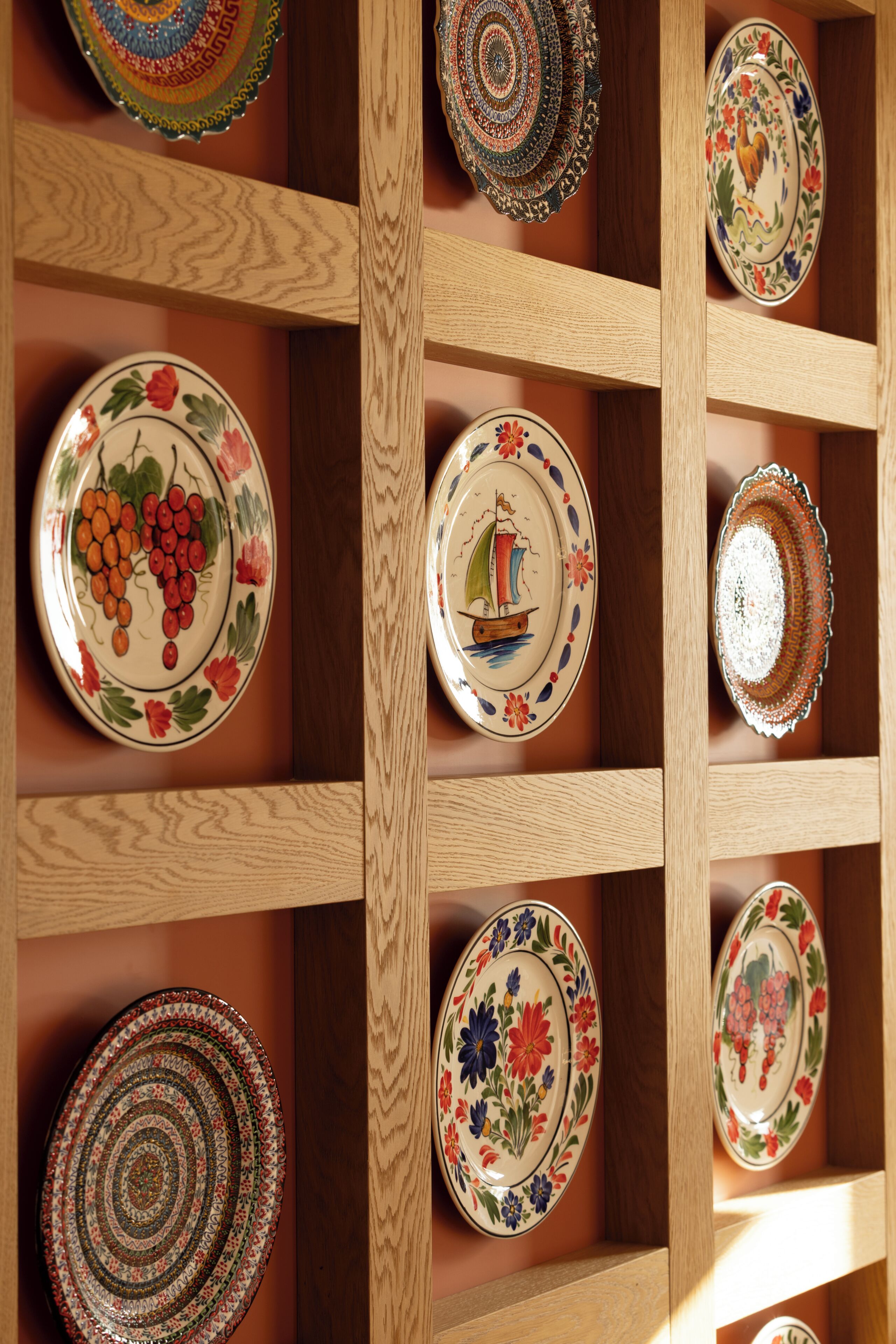 Una estantería de madera con varios platos decorativos.