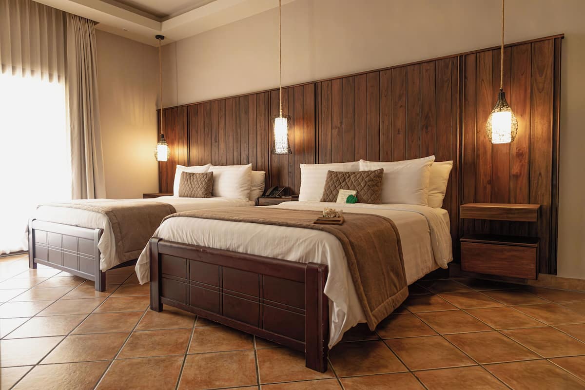 A double bed with a wooden headboard, two bedside tables, and a nightstand.