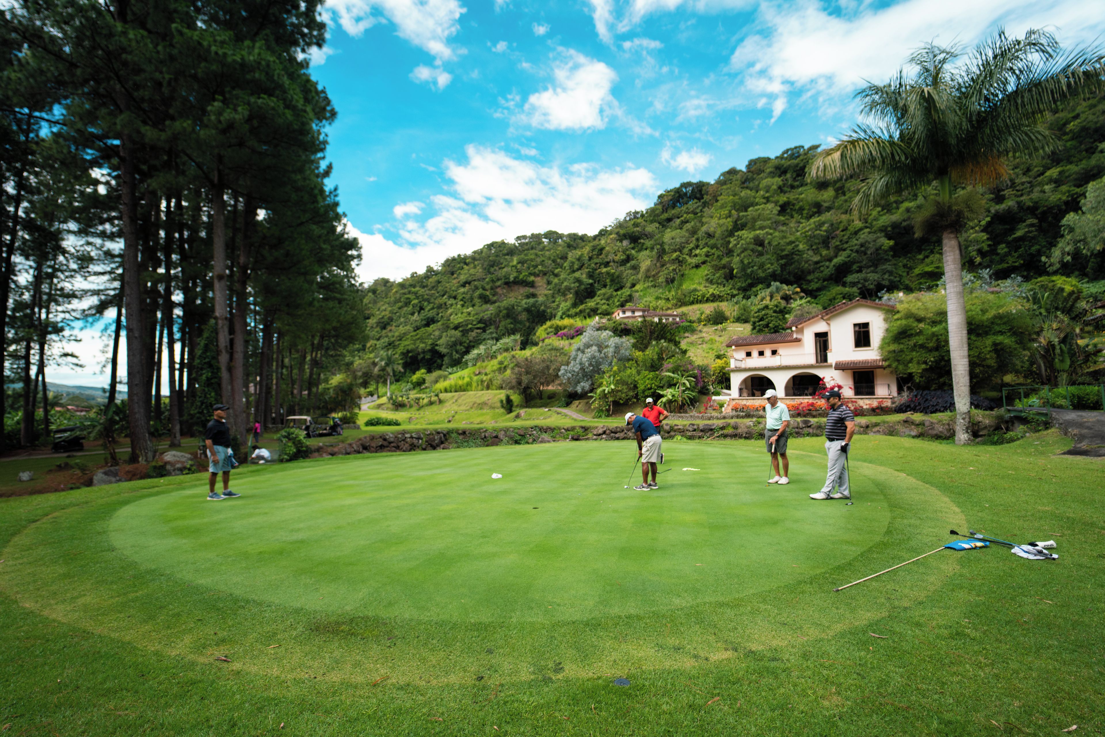 A golf course with a clubhouse and surrounding greenery.