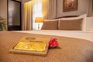 Una cama bien hecha con cabecera de madera, almohada y un objeto decorativo sobre la cama.
