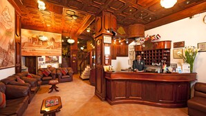 A lobby with a reception desk, leather sofas, a staircase, and a chandelier. - HOTEL MABEY CUSCO (Cusco)