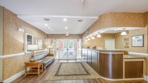 A hotel lobby with a reception desk, seating area, and a view of the outside. - MainStay Suites Port Saint Joe South (Port St. Joe)