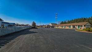 Ein Motel mit Parkplatz, Waschstraße und einer Reihe eingeschossiger Gebäude mit grünen Türen.