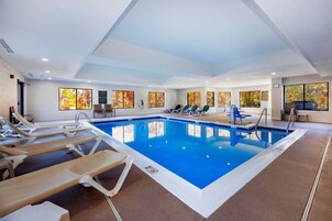 Una piscina techada, sillones reclinables de piscina