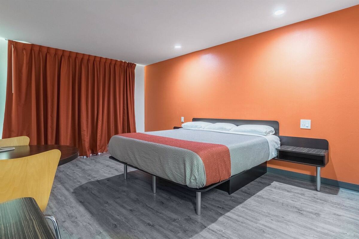 A hotel room with a bed, a desk, and a chair.