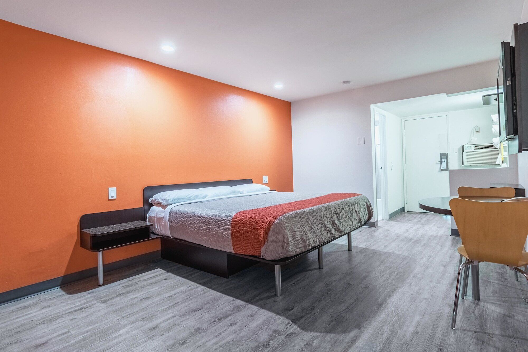 Une chambre d’hôtel moderne, équipée d’un lit, d’un bureau et d’une chaise.