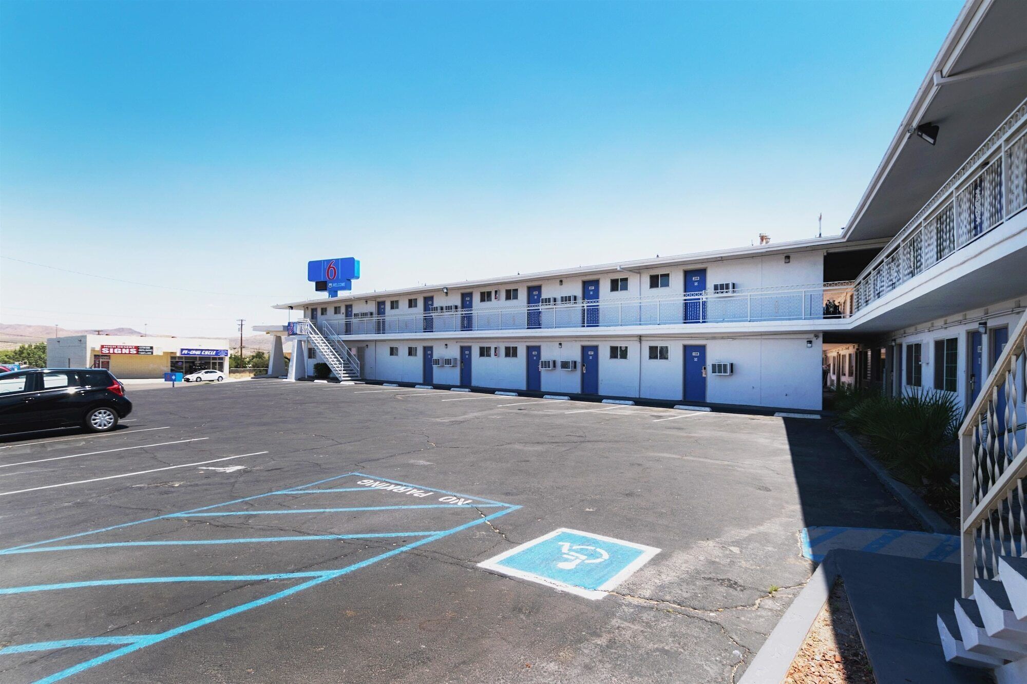 Ein Motel mit Parkplatz, markierten Stellplätzen und einem Schild mit der Motelnummer.