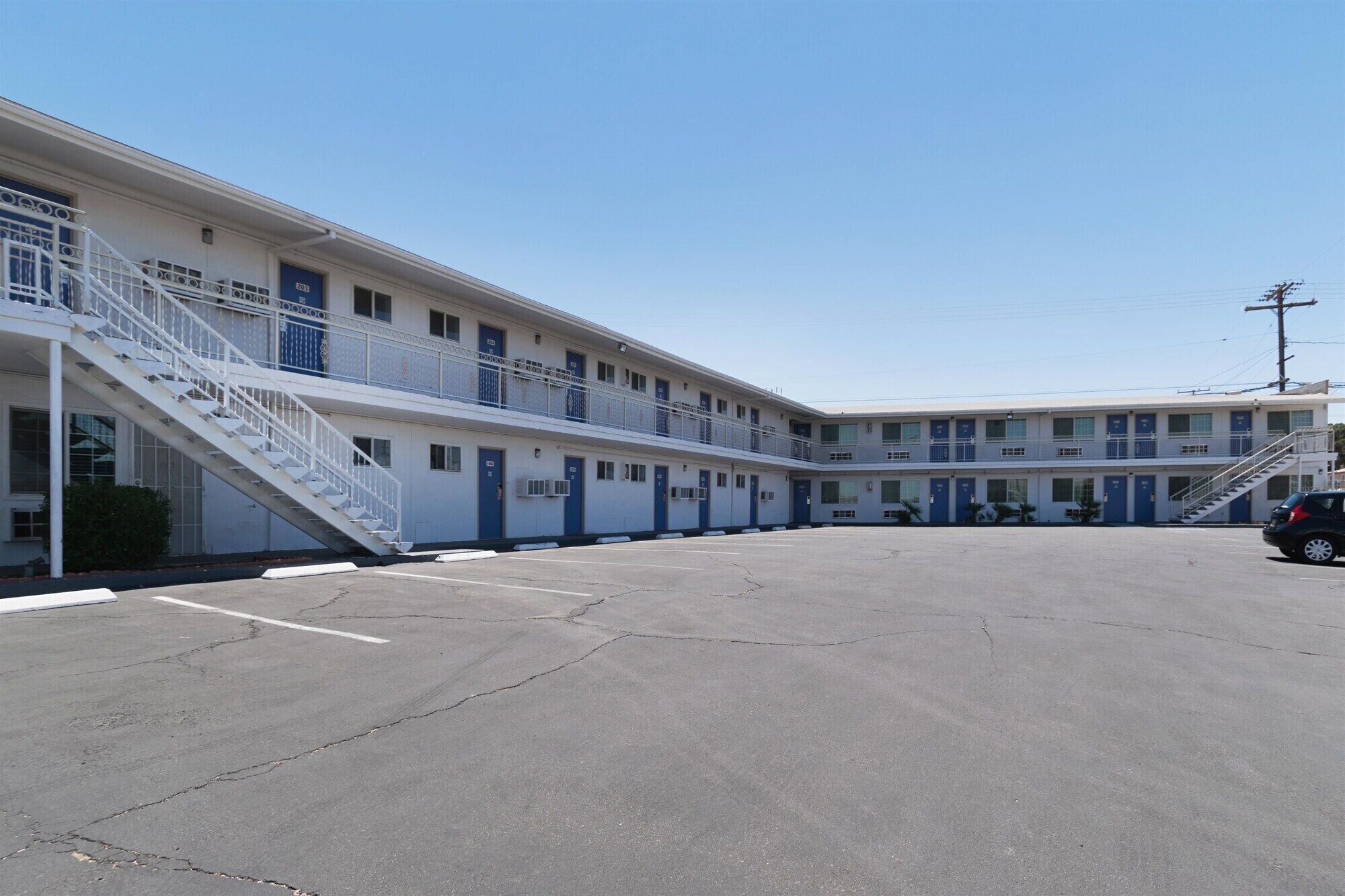 A motel with a central courtyard, multiple balconies, and a parking lot.