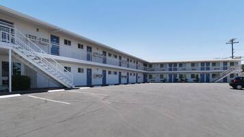 A motel with a central courtyard, multiple balconies, and a parking lot.