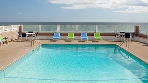 A pool area with a clear view of the ocean, lounge chairs, and a table with chairs. - Bluegreen Vacations The Breakers Resort, an Ascend Collection Resort (Dennis Port)