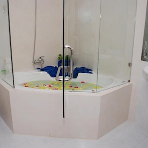 A modern bathroom with a glass-enclosed bathtub, a shower, and a white sink. - Ocean Star Resort (Phan Thiet)
