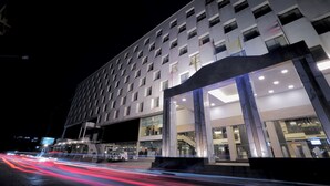 Un hôtel moderne doté d’une entrée imposante et de plusieurs étages.