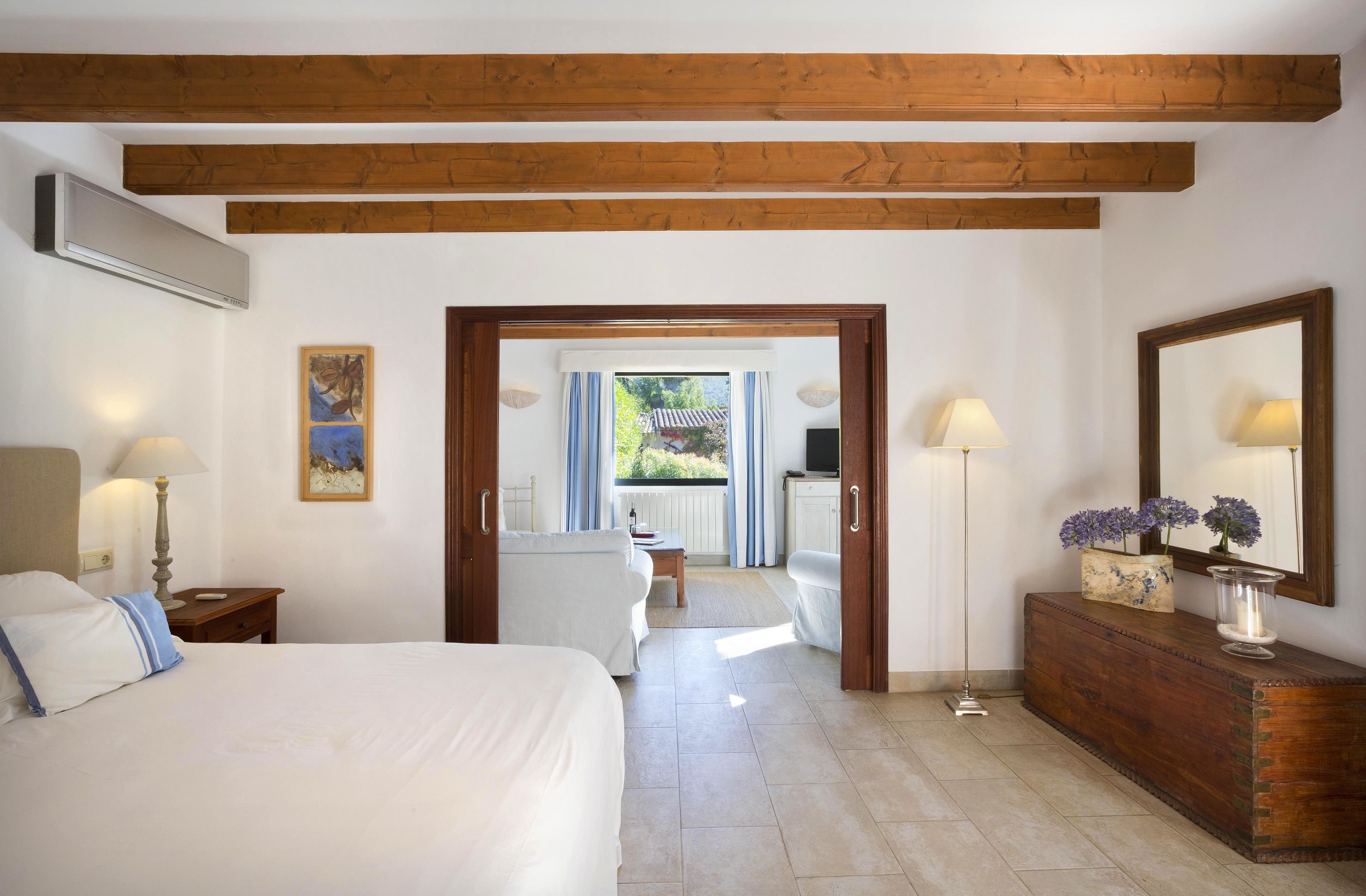Habitación de hotel con una cama, un aparador de madera, un escritorio y vistas al exterior.