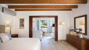 Habitación de hotel con una cama, un aparador de madera, un escritorio y vistas al exterior.