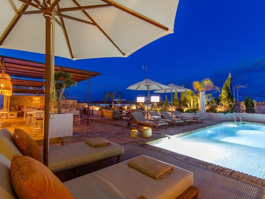 Una piscina al aire libre, sombrillas, tumbonas