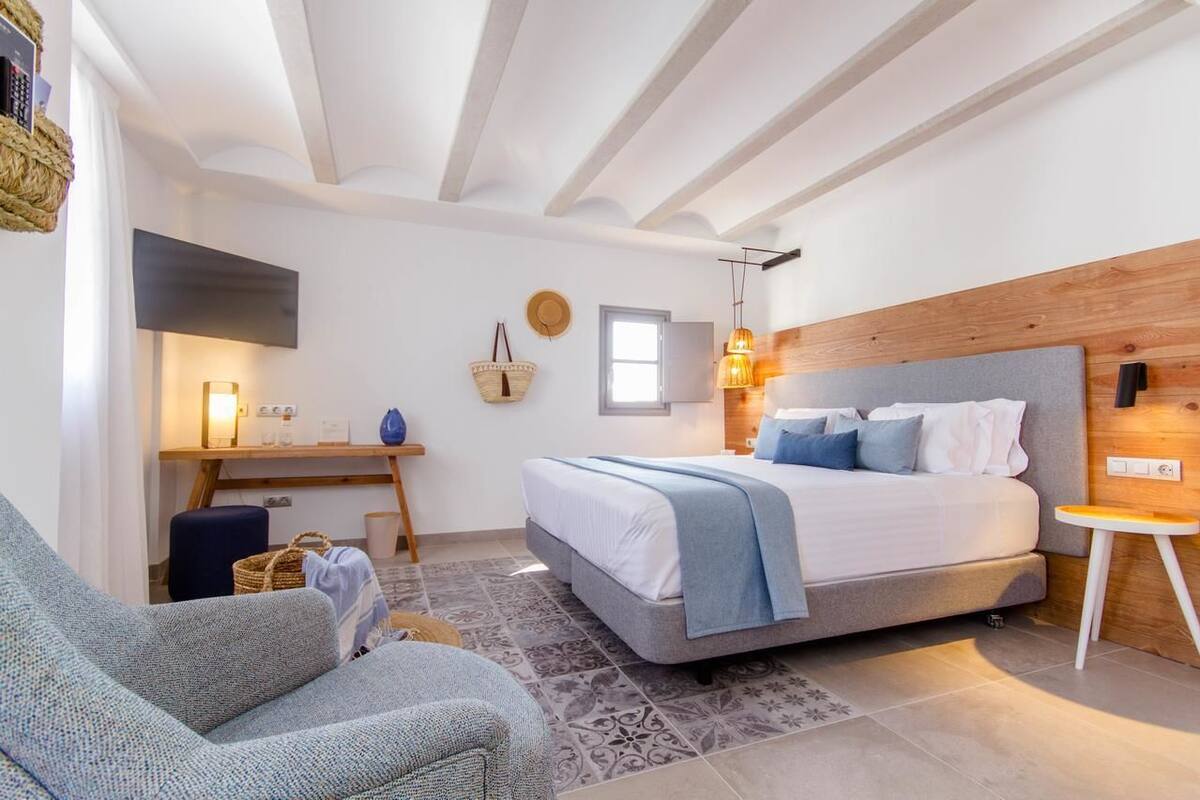 Un dormitorio con cama, escritorio y silla.