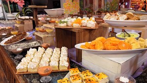 A buffet with various desserts and fruits.