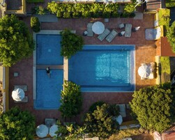 Una piscina al aire libre, sombrillas, tumbonas