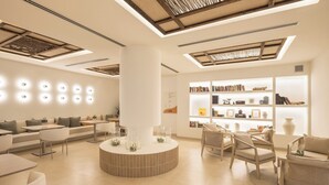 Un interno moderno con un tavolo rotondo al centro, posti a sedere e una libreria con libri e oggetti decorativi.