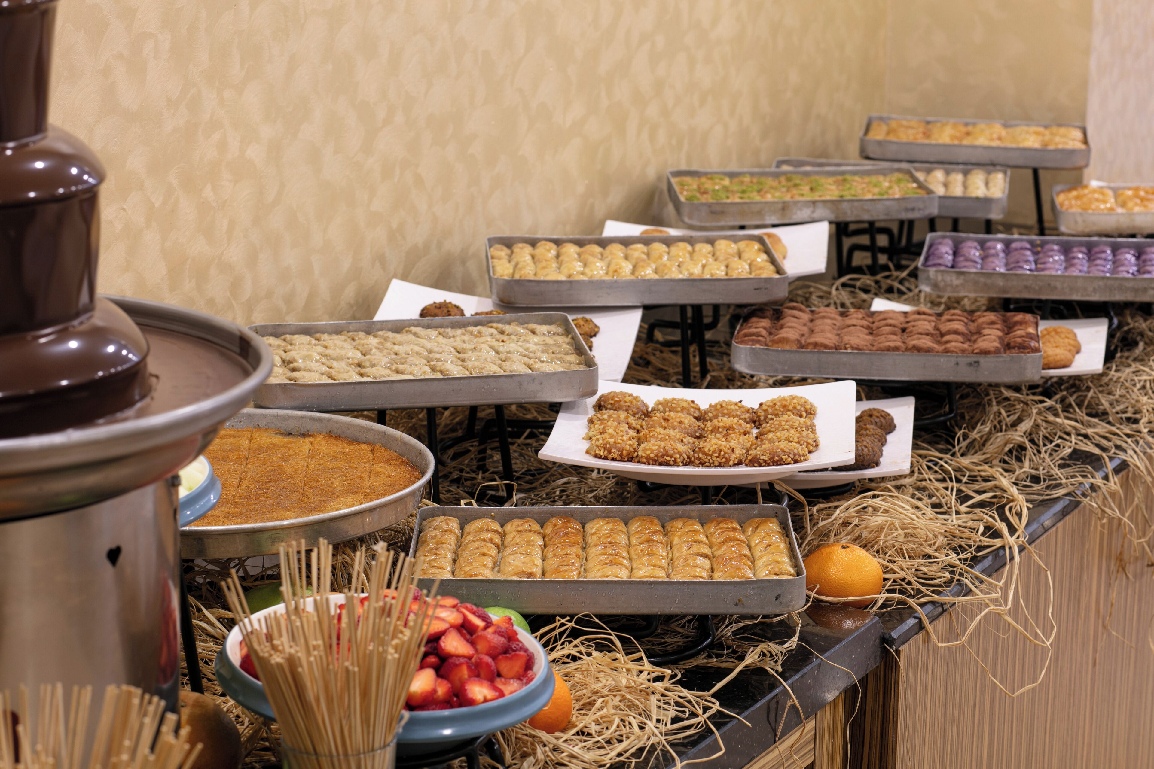 A buffet with various food items including pastries, fruits, and desserts.