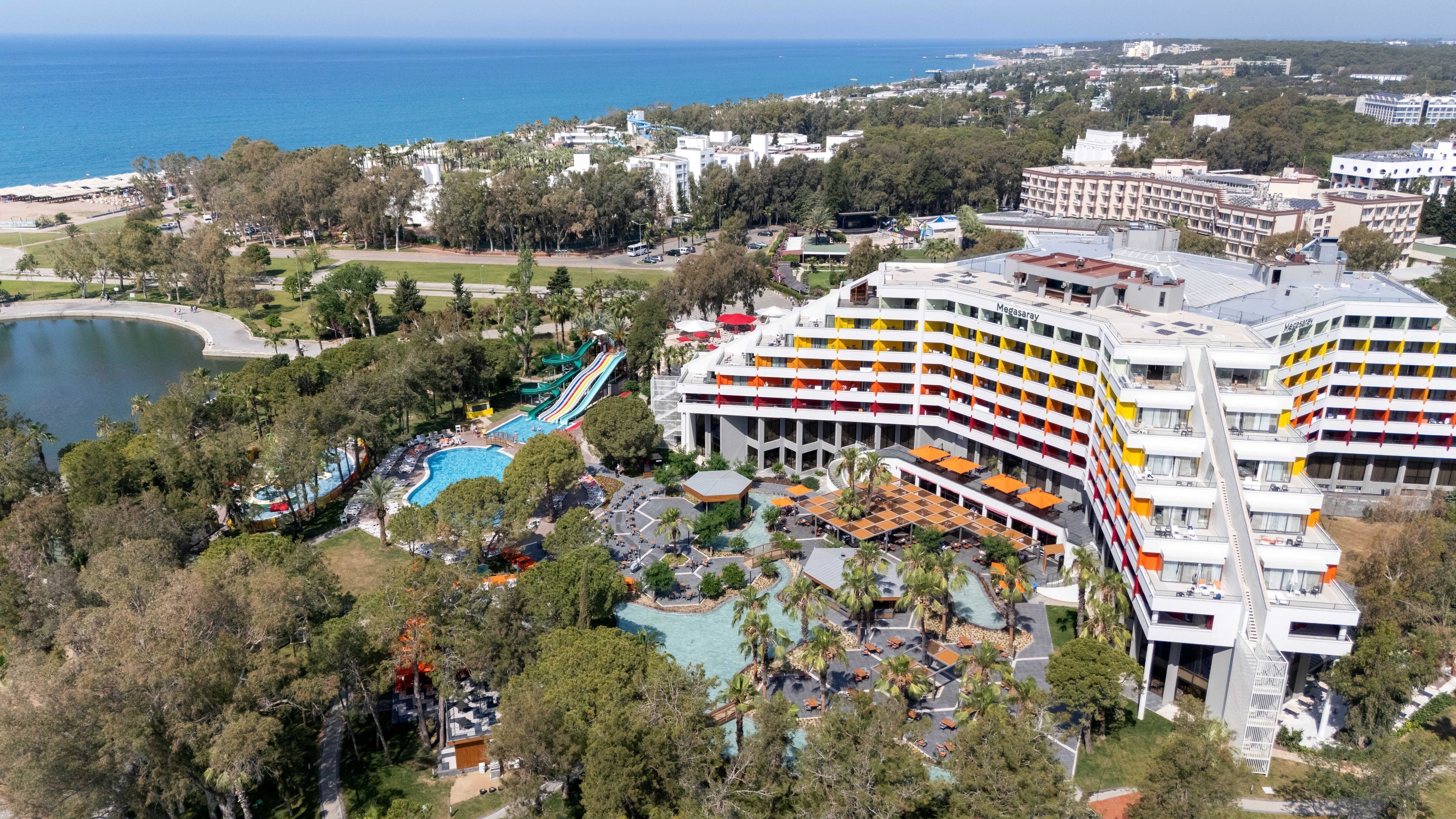 Un complexe hôtelier doté d’une piscine, de toboggans aquatiques et d’un grand bâtiment avec des balcons.