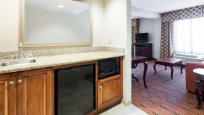 A compact kitchen with a dishwasher, microwave, and a large mirror above the sink. - Hampton Inn Moss Point Pascagoula (Moss Point)