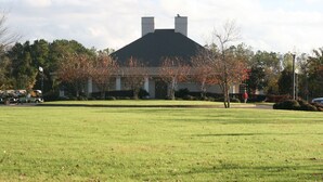 A building with a symmetrical facade, two chimneys, and a lawn in the foreground. - Hampton Inn Moss Point Pascagoula (Moss Point)