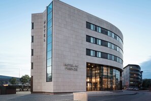 A modern hotel building with a curved facade, large glass windows, and a prominent "HOTEL" sign on the side. - AC Hotel Firenze by Marriott (Florence)