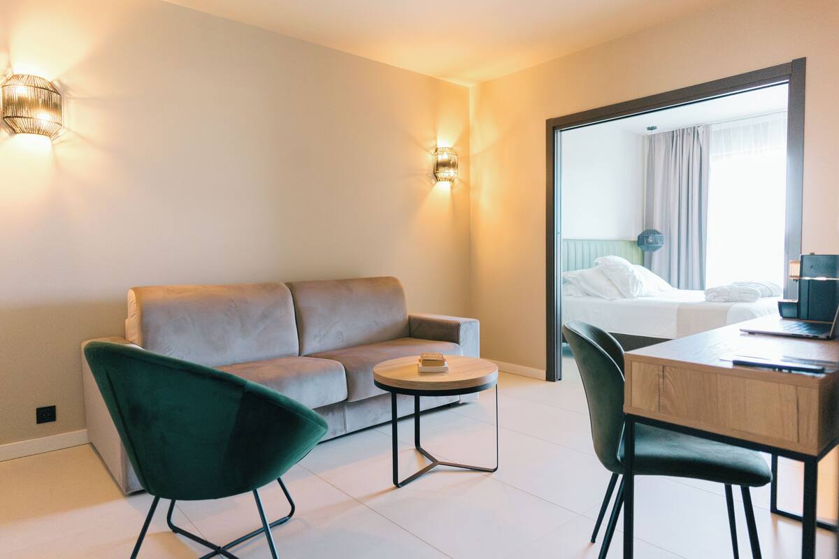 Une chambre d’hôtel moderne avec un canapé, une table ronde et une chaise.